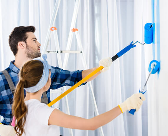 boyfriend and girlfriend painting wall with blue p LXL5578