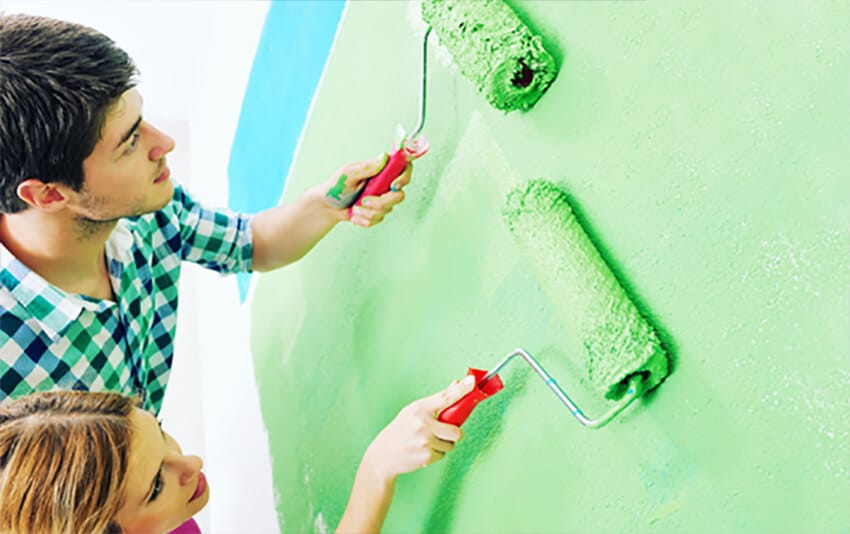 happy couple paint wall at new home PHDT2VB